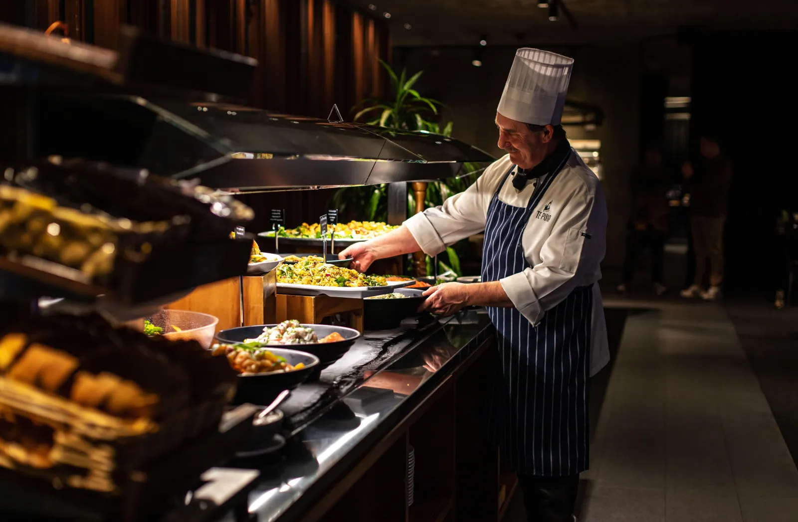 Chef serving the hāngī buffet at Te Puia's Pātaka Kai Restaurant