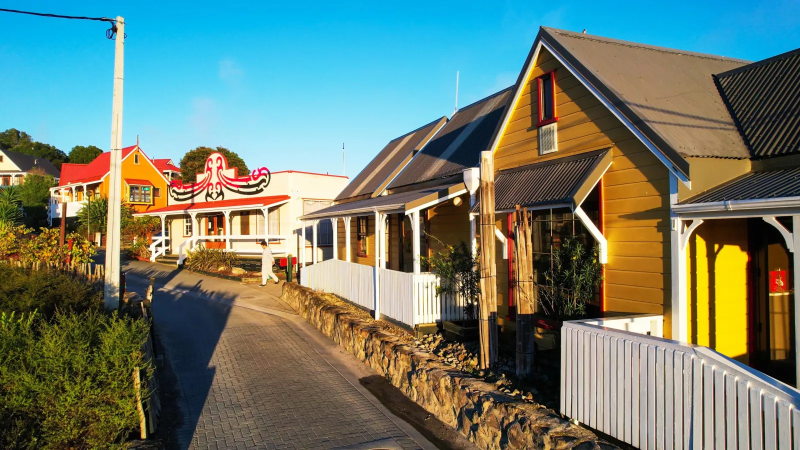 A village street of painted houses with geothermal steam drifting between them