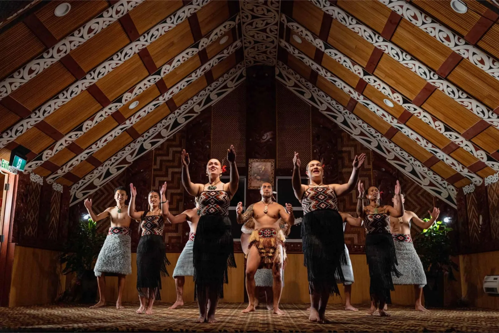 Performers with poi inside Te Aronui a Rua, Te Puia's carved meeting house